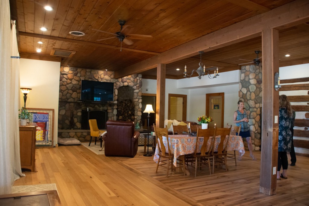 As soon as you enter the home your eye meets a huge stone fireplace, tall ceilings and beautifully restored wood flooring. The flooring in the center was found in an old barn, was original to the home, and was fully restored by the Grolls.